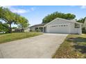 Well-manicured lawn leading to a charming single-story home with an attached two-car garage at 12204 Pepper Mill Dr, Hudson, FL 34667