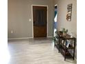 Neutral foyer featuring wood-look floors, a front door and modern storage console at 13111 Sheridan Dr, Hudson, FL 34667