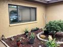 Side courtyard with large window and small garden with rock ground cover at 13111 Sheridan Dr, Hudson, FL 34667