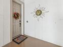 Front doorway with floral wreath, sun decoration, welcome mat, and sidelight at 1340 Bayshore Blvd # 411, Dunedin, FL 34698
