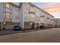 Townhome exterior featuring attached garages, stucco facade, and sunset sky at 1340 Bayshore Blvd # 411, Dunedin, FL 34698