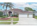 Charming single-story home featuring a three-car garage, a well-manicured lawn, and mature landscaping at 13942 Talmage Loop, Hudson, FL 34667