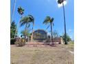 Deerfield community sign surrounded by mature palm trees and landscaping under a clear blue sky at 15585 Rene Ct, Brooksville, FL 34604