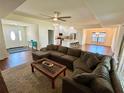 Open-concept living space features a large sectional sofa and seamless flow into the kitchen and dining area at 15585 Rene Ct, Brooksville, FL 34604