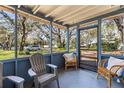 Screened porch with seating, providing a comfortable outdoor living space with neighborhood views at 1916 & 1910 Beachway Ln, Odessa, FL 33556
