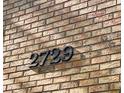 Close-up of the house number '2729' in dark numerals mounted on a brick wall at 2729 Penzance St, Palm Harbor, FL 34684
