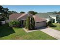 Charming single-story home featuring a two-car garage, well-manicured lawn, and mature landscaping at 3054 Oakbrook Cir, Clearwater, FL 33759