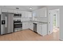 Updated kitchen with white cabinets, granite countertops, stainless steel appliances, and subway tile backsplash at 3141 Loomis Dr, New Port Richey, FL 34655