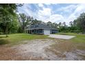 Spacious single-story home with an attached garage, large driveway, and expansive green lawn at 3355 La Vista St, Brooksville, FL 34604