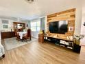 A bright living room featuring dining area, wood flooring, and accent wall at 3752 Fox Dale Ln, Holiday, FL 34691
