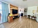 Bright living room with wood flooring, accent wall, and comfortable seating area at 3752 Fox Dale Ln, Holiday, FL 34691