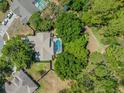 Aerial shot showcasing a backyard pool surrounded by lush greenery and neighboring properties at 446 Romine Ct, Spring Hill, FL 34609