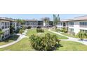 Landscaped community grounds, a well-maintained exterior with winding sidewalks, palm trees, and green grass at 4726 Marine Pkwy # 201, New Port Richey, FL 34652