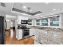 Modern kitchen boasts granite countertops, stainless steel appliances, and lots of natural light from multiple windows at 4837 Prince George Cir, New Port Richey, FL 34655