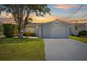 Charming single-story home with a well-maintained lawn and attached one car garage at sunset at 5106 Blue Heron Dr, New Port Richey, FL 34652