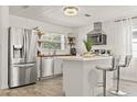 Modern kitchen features stainless steel appliances, an island with seating and wood look floors at 5106 Blue Heron Dr, New Port Richey, FL 34652