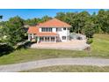 Stunning home featuring a red tile roof, large windows, and a spacious patio overlooking the pool at 5198 Legend Hills Ln, Brooksville, FL 34609
