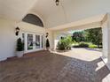Welcoming front entrance with double glass doors, elegant lighting, and a covered porch at 5198 Legend Hills Ln, Brooksville, FL 34609