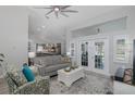 Bright living room with vaulted ceiling, ceiling fan, and sliding glass doors leading to the backyard at 5607 Wellfield Rd, New Port Richey, FL 34655