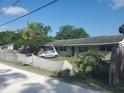 Exterior front of house with car behind fence and view of landscape and sky at 5821 Michigan Ave, New Port Richey, FL 34652