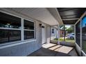 View of the covered and screened front porch with concrete flooring that offers an inviting entry into the home at 7321 Parrot Dr, Port Richey, FL 34668