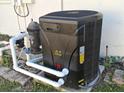 Image of the pool heating system. Includes filter and heater with pipes at 7508 Cypress Knee Dr, Hudson, FL 34667