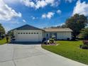 Charming one-story home featuring an attached garage and a well-maintained front yard with lush landscaping at 8340 Divot Way, Port Richey, FL 34668