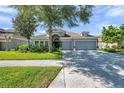 Single-story home featuring an arched entry, beautiful landscaping and a convenient two-car garage at 8635 Creedmoor Ln, New Port Richey, FL 34654