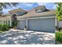 Charming home showcasing a two-car garage, an arched entry and manicured landscaping at 8635 Creedmoor Ln, New Port Richey, FL 34654