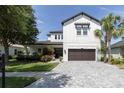 Beautiful two-story home with landscaped front yard, brick driveway, and a two-car garage at 8945 Bella Vita Cir, Land O Lakes, FL 34637