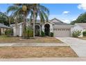 Charming home featuring a two-car garage, mature landscaping, and a well-manicured lawn at 9104 Water Hazard Dr, Hudson, FL 34667