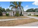 Charming home featuring a two-car garage, mature landscaping, and a well-manicured lawn at 9104 Water Hazard Dr, Hudson, FL 34667