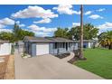 Charming single-story home with blue exterior, well-manicured lawn, and long driveway at 9141 Greenbriar Ln, Port Richey, FL 34668
