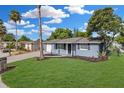 Charming single-story home with blue exterior, well-manicured lawn, and a lovely mailbox at 9141 Greenbriar Ln, Port Richey, FL 34668
