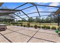 An outdoor patio with a screened enclosure showcases the paver flooring, hot tub, and the beautiful golf course view at 9208 Butler Blvd, Weeki Wachee, FL 34613