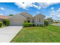 Inviting single-story home featuring a manicured lawn, trimmed hedges, and an attached two-car garage on a sunny day at 9400 New Orleans Dr, Weeki Wachee, FL 34613