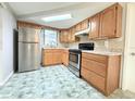 Kitchen featuring stainless steel appliances, wood cabinets, and tile backsplash at 9850 Richwood Ln, Port Richey, FL 34668
