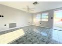 Bright living room with tile flooring and a ceiling fan at 9850 Richwood Ln, Port Richey, FL 34668