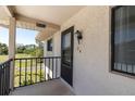 Balcony view featuring a 'Welcome' sign, railing, exterior home details, and pleasant green space view at 9970 Eagles Point Cir # 3, Port Richey, FL 34668