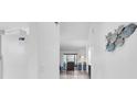 Bright hallway with decor leading into a well-lit living space, highlighting a clean and airy ambiance at 9970 Eagles Point Cir # 3, Port Richey, FL 34668