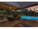 Outdoor covered patio with fireplace and furniture overlooking the pool and expansive yard at 1033 Tuscany Dr, Trinity, FL 34655