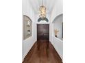 Elegant foyer with dark wood flooring, double doors, chandelier and decorative wall accents creating a grand entrance at 12800 Solola Way, Trinity, FL 34655