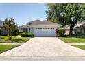 Charming single-story home with brick driveway and well-manicured lawn at 14105 Agua Clara Dr, Hudson, FL 34667