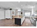 Open kitchen with granite counters, island seating, and wood flooring at 14105 Agua Clara Dr, Hudson, FL 34667