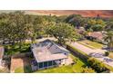 An aerial view showcases the home's screened in patio and fenced yard, nestled among lush trees in a residential neighborhood at 2116 Karan Way, Clearwater, FL 33763