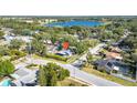 This aerial shows the home and surrounding neighborhood near a beautiful blue lake surrounded by lush trees and a community pool at 2116 Karan Way, Clearwater, FL 33763