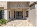 Inviting front porch with double doors, neutral colored stucco and a lattice wall above at 2235 Lytham Ct, Spring Hill, FL 34606