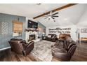Cozy living room featuring a fireplace, wood beam, ceiling fan and comfortable seating for relaxation at 2254 Coachman Rd, Spring Hill, FL 34608
