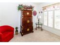 Bright living room boasts plantation shutters, plush carpeting and a unique armoire at 2325 Pleasant Hill Ln, Holiday, FL 34691