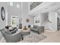 Bright living room with soaring ceilings, sleek furniture, and a staircase leading to the upper level at 2815 Dudley Ave, Odessa, FL 33556